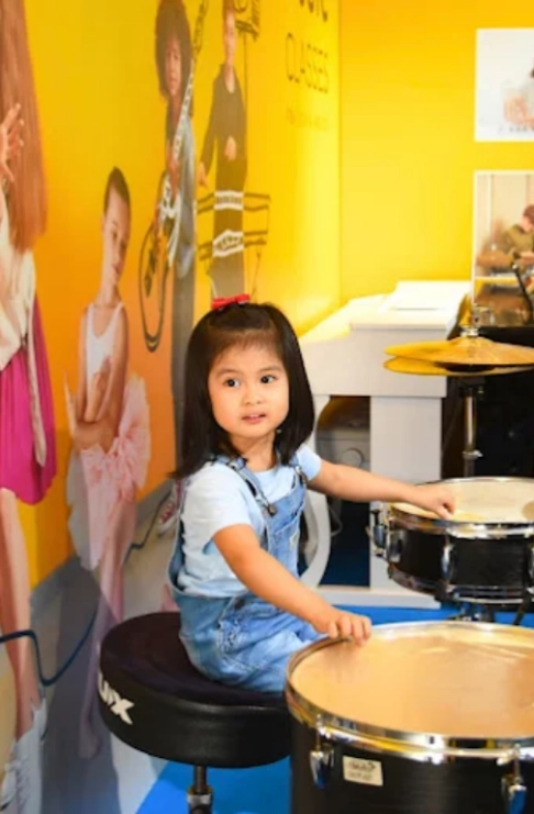 Melodica Music Academy Melodica Music Academy – Abu Dhabi Cute Girl Playing Drum